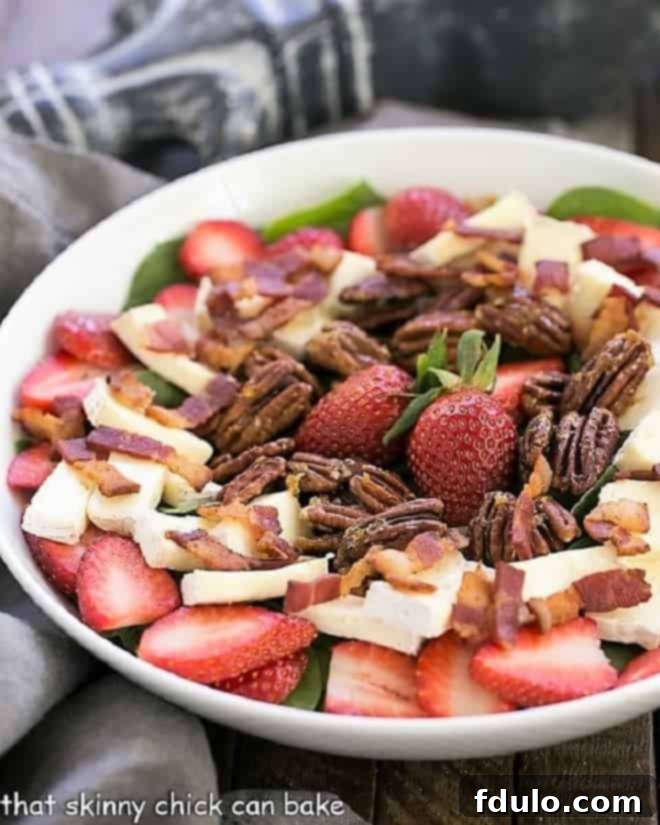 Strawberry Bacon Brie Salad in a pristine white serving bowl, showcasing its vibrant ingredients.