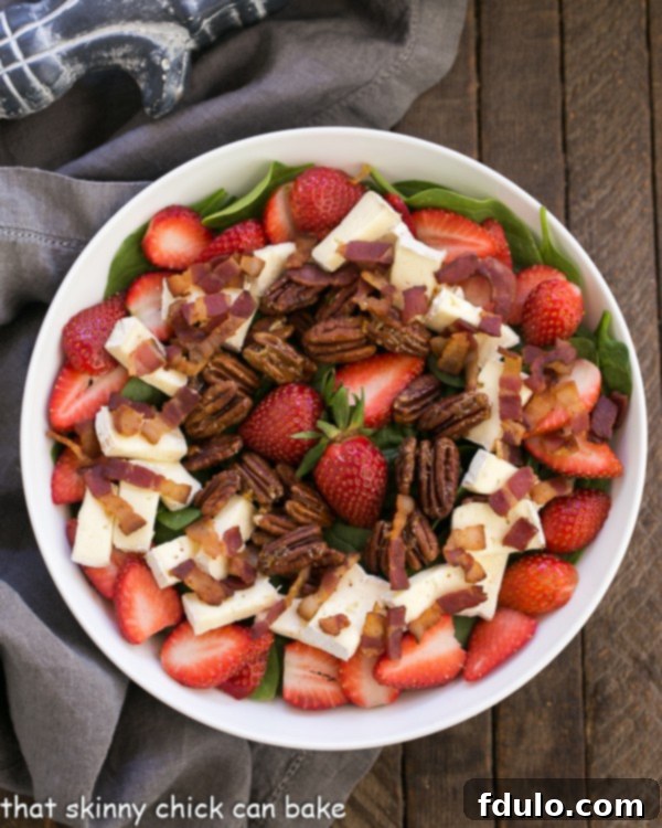 Strawberry Bacon Brie Salad in a round white serving bowl from an overhead perspective.