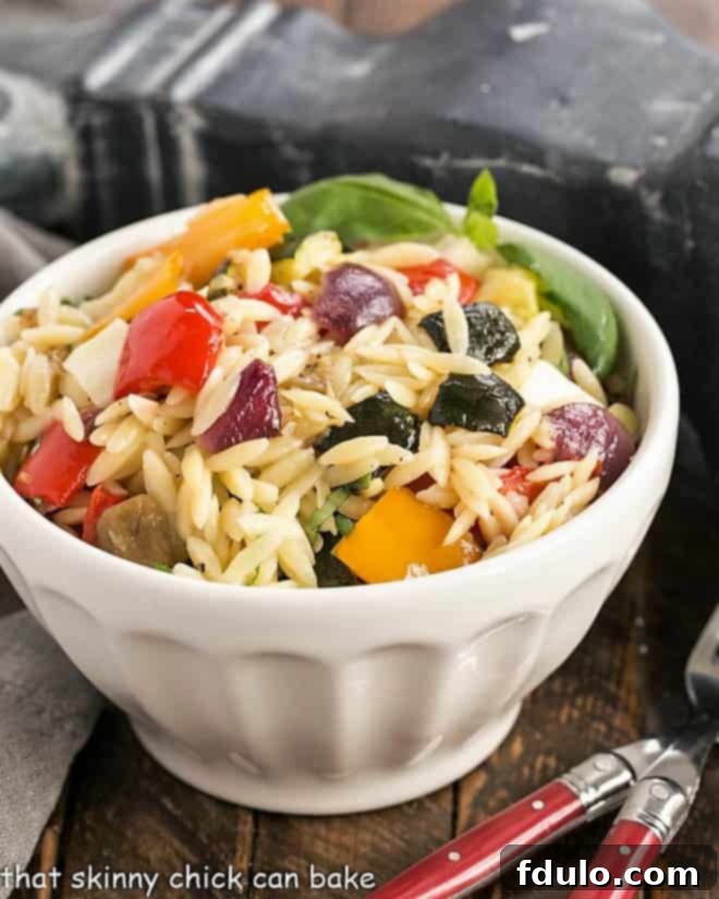 Vibrant Orzo Salad with Roasted Vegetables and Fresh Mozzarella in a large white serving bowl, perfect for sharing.