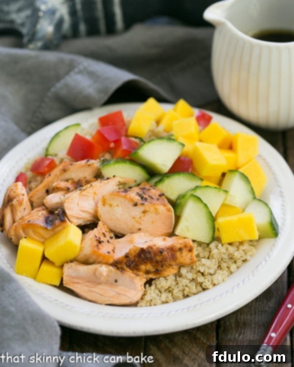 A close-up of Caribbean Salmon Quinoa Salad, featuring jerk salmon, quinoa, mango, and fresh vegetables Vibrant Caribbean Salmon Quinoa Salad on a white plate, showcasing colorful ingredients
