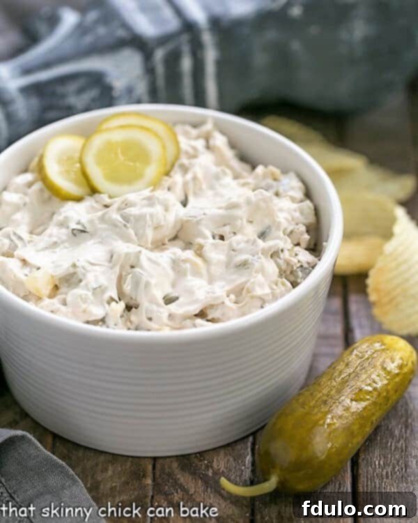 Easy Dill Pickle Dip - Get prepared for rave reviews! Only 5 ingredients! Easy Dill Pickle Dip in a serving bowl with a pickle and ruffled chips. A perfect easy appetizer for parties and gatherings.