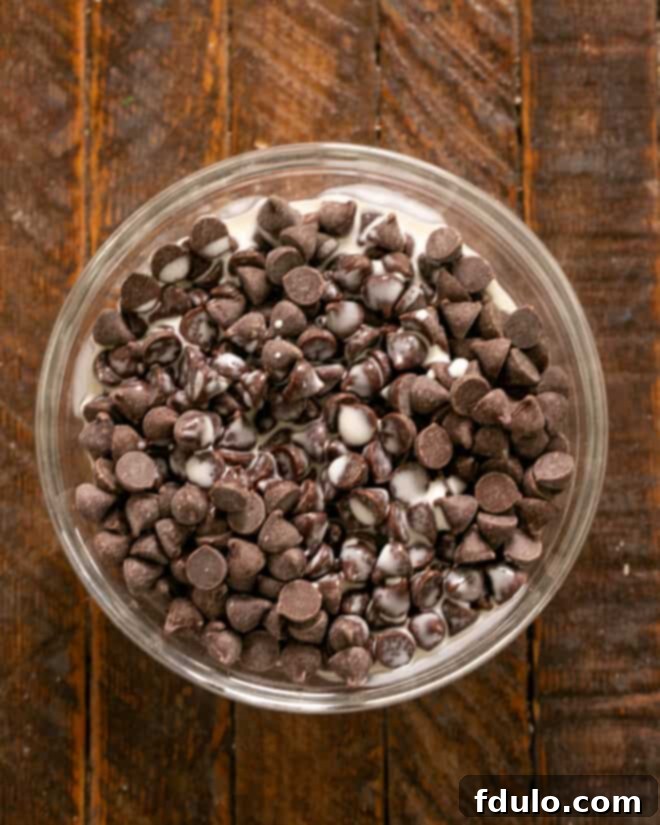 Chocolate chips with heavy cream in a bowl.