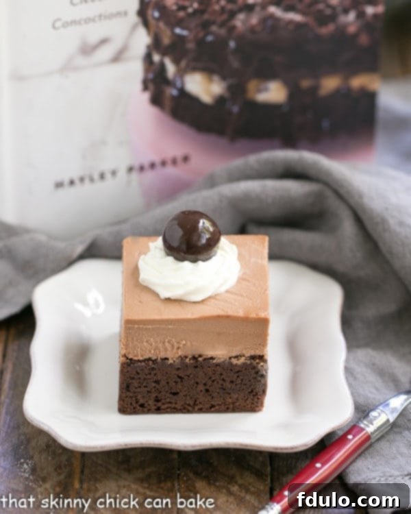 A French Silk Pie Brownie on a white ceramic plate, with a red-handled fork having just taken a perfect bite.