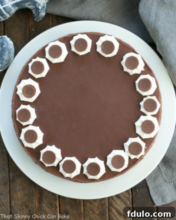 Overhead view of a beautiful, perfectly circular Chocolate Peanut Butter Pie on a white cake plate.