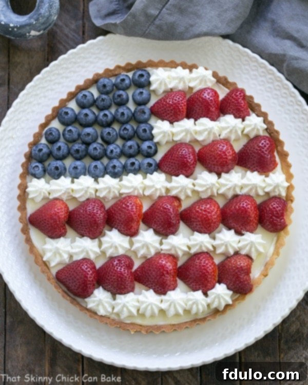 Overhead view of an American Flag Fruit Tart on white serving plate, perfectly arranged.
