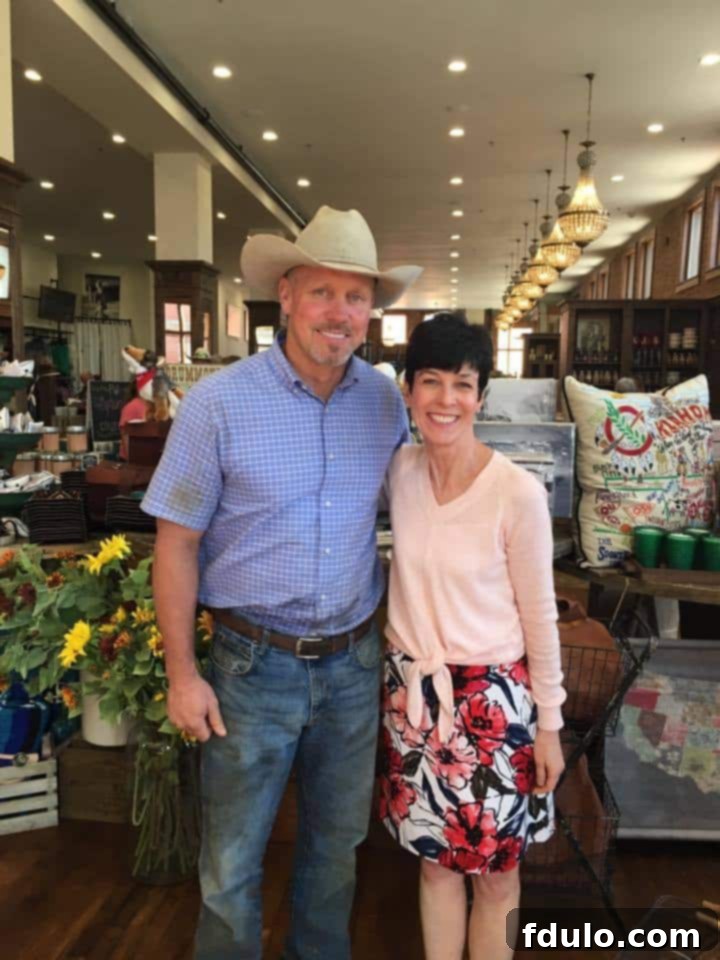 Liz Berg posing with Ladd Drummond, famously known as Marlboro Man, in the bustling retail shop at The Mercantile in Pawhuska, Oklahoma, a memorable encounter.