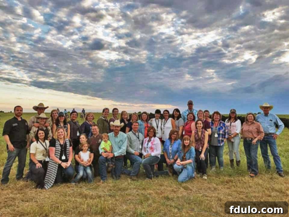 A cheerful group of food bloggers gathered together in a picturesque cattle country setting, smiling warmly, showcasing the camaraderie and shared experiences of their Kansas trip.