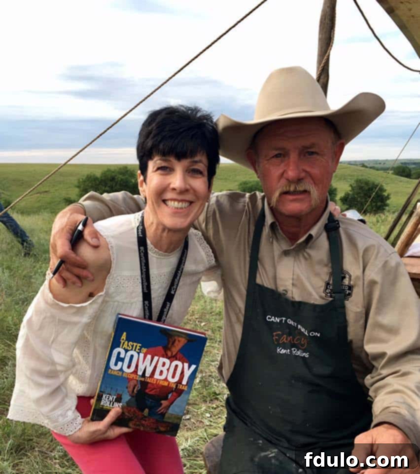 Liz Berg, the author, standing proudly beside the cowboy culinary expert and cookbook author, Kent Rollins, with a copy of his book in hand, capturing a memorable moment from the Kansas trip.