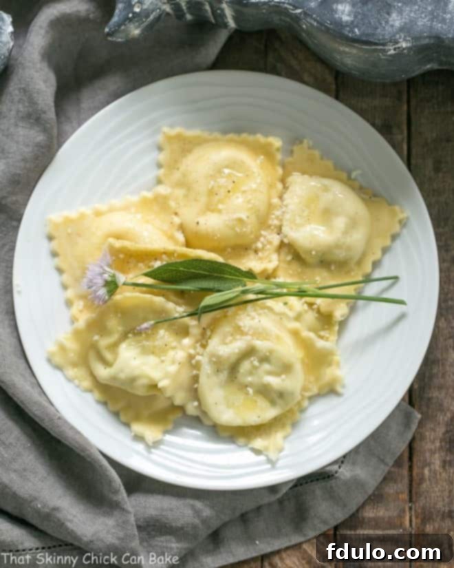 Overhead view of Mozzarella, Basil, Parmigiano-Reggiano Ravioli with Butter Sage Sauce on a white dinner plate