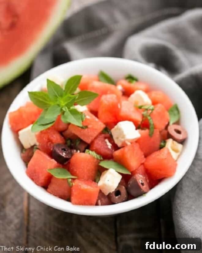 A beautifully arranged Watermelon Feta Basil Salad with Balsamic Vinaigrette in a pristine white bowl, ready to be served.