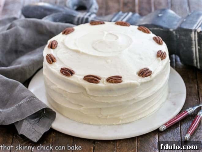 Hummingbird Cake with Coconut - A dense, banana cake chock full of pecans, coconut and pineapple and slathered in cream cheese frosting! Hummingbird Cake Recipe with coconute on a serving platter.