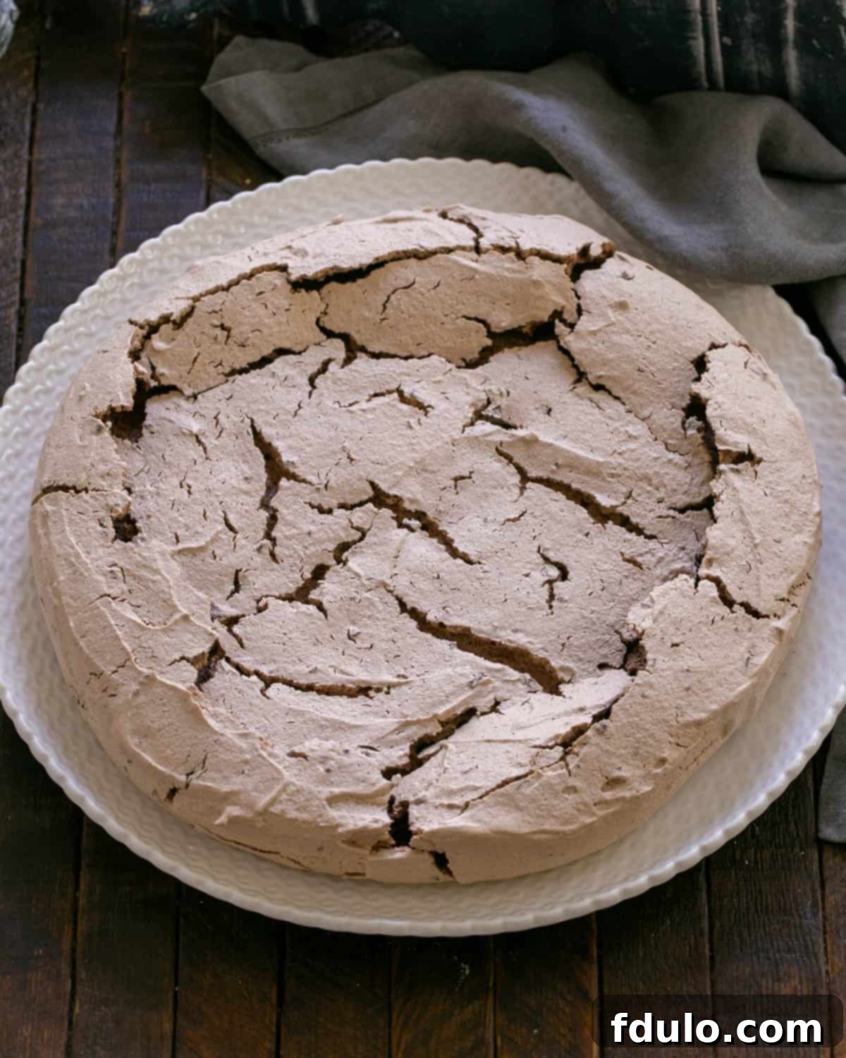 A baked chocolate pavlova shell cooling after being removed from the oven.