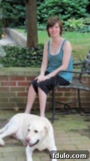 Katie sitting peacefully on an outdoor bench with a friendly dog by her side, enjoying the serene surroundings, a picture of contentment