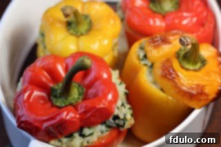 Dorie Greenspan's cheesy rice packed peppers, a close-up of the finished dish with melted cheese and herbs.