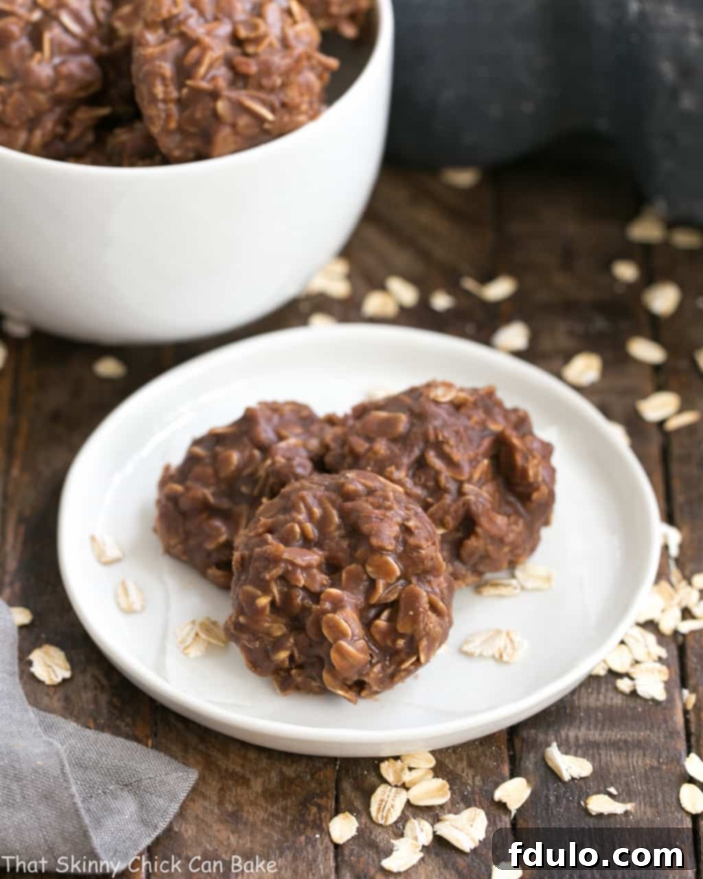 Classic Chocolate Peanut Butter No Bake Cookies on a round white plate with a bowl of cookies in the background.