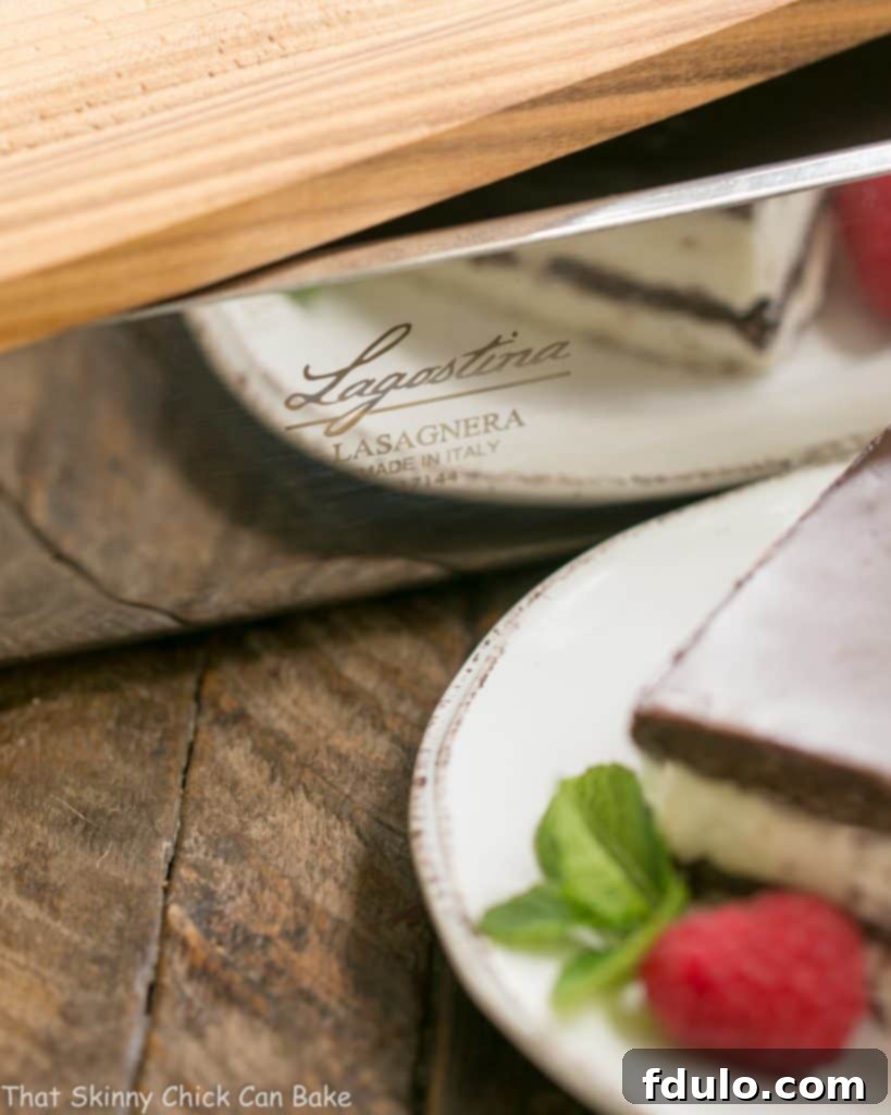 A close-up of the assembled No-Bake Chocolate Lasagna in a baking dish before chilling, showing the even layers of graham crackers and creamy chocolate filling.