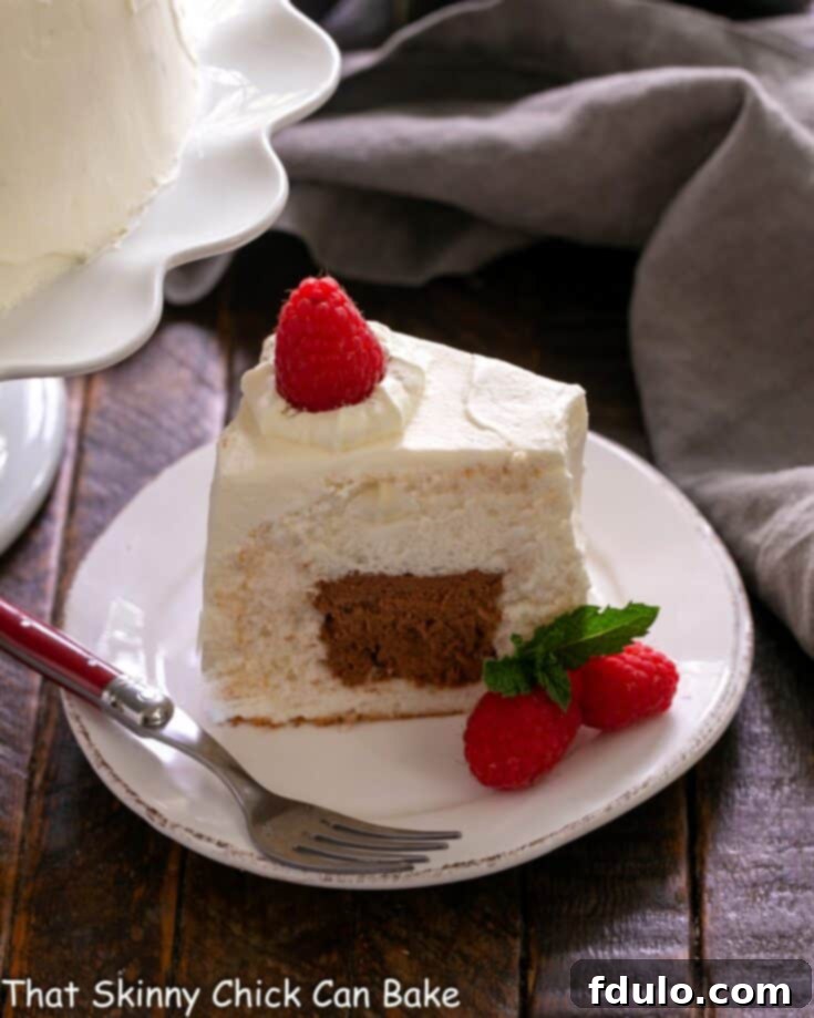 Slice of Mousse Filled Angel Food Cake on a white dessert plate, with raspberries.