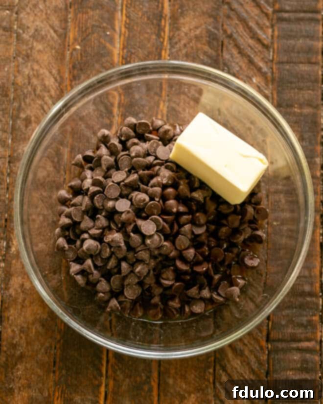 Melting butter and semi-sweet chocolate chips together in a microwave-safe bowl.