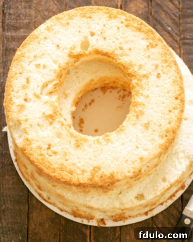 Carefully slicing the top off an angel food cake to prepare it for filling.