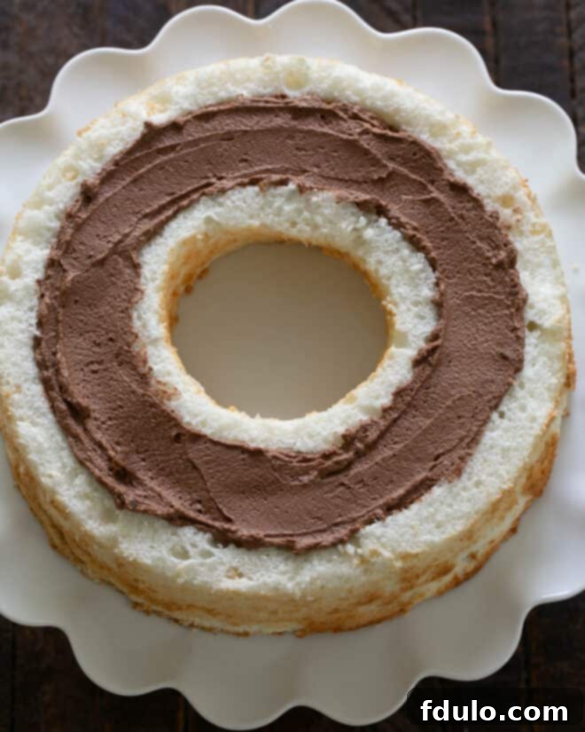 Overhead view of the bottom section of an angel food cake, already filled with rich chocolate mousse.