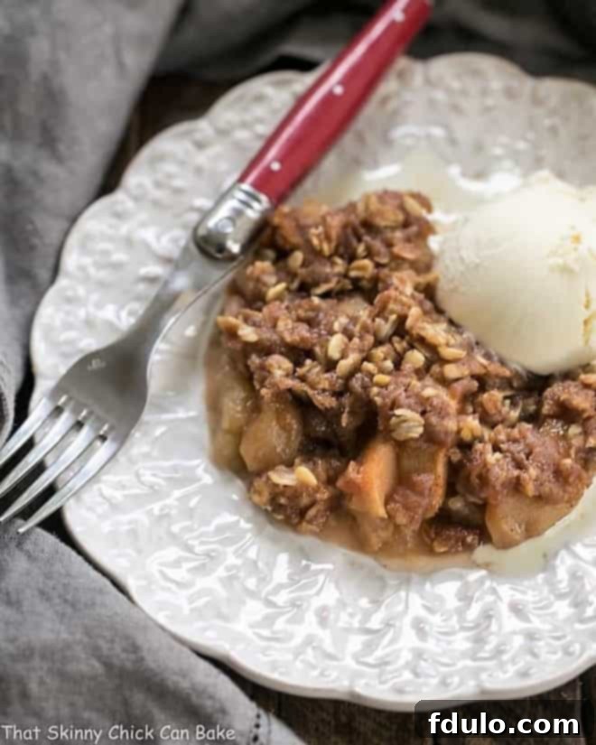 Easy Slow Cooker Apple Crisp on a decorative white plate, ready to be served, highlighting the tender apples and crumbly topping.