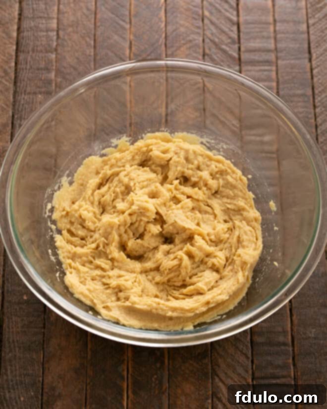 Hearty Cowboy Cookies: The Recipe You Need 4 Step 2: Mixing eggs and vanilla extract into the creamed butter and sugar mixture.