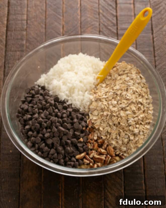 Hearty Cowboy Cookies: The Recipe You Need 6 Step 4: Folding in chocolate chips, oats, coconut, and pecans into the cookie dough.