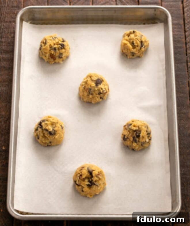 Hearty Cowboy Cookies: The Recipe You Need 7 Step 5: Scooping cookie dough balls onto a baking sheet lined with parchment paper.