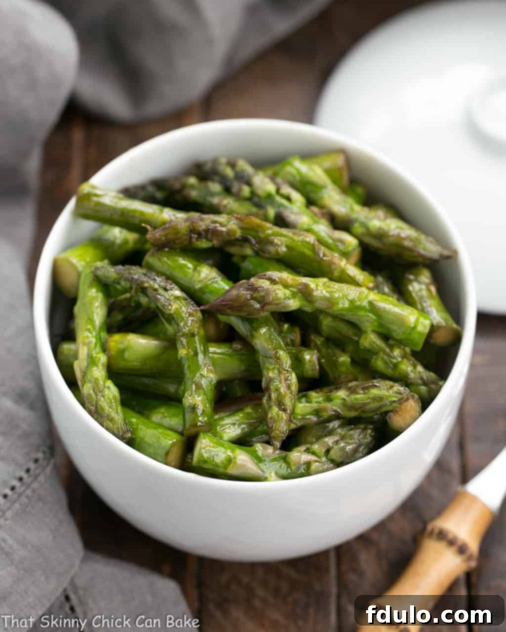 Vibrant Asian Asparagus Stir-fry 3 A beautifully arranged white bowl filled with freshly prepared Asian Stir-Fried Asparagus, ready to be served as a delicious side dish.