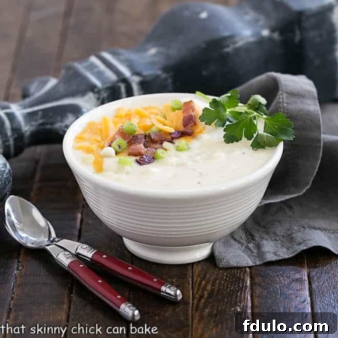 Easy Potato Soup in a white bowl with two soup spoons