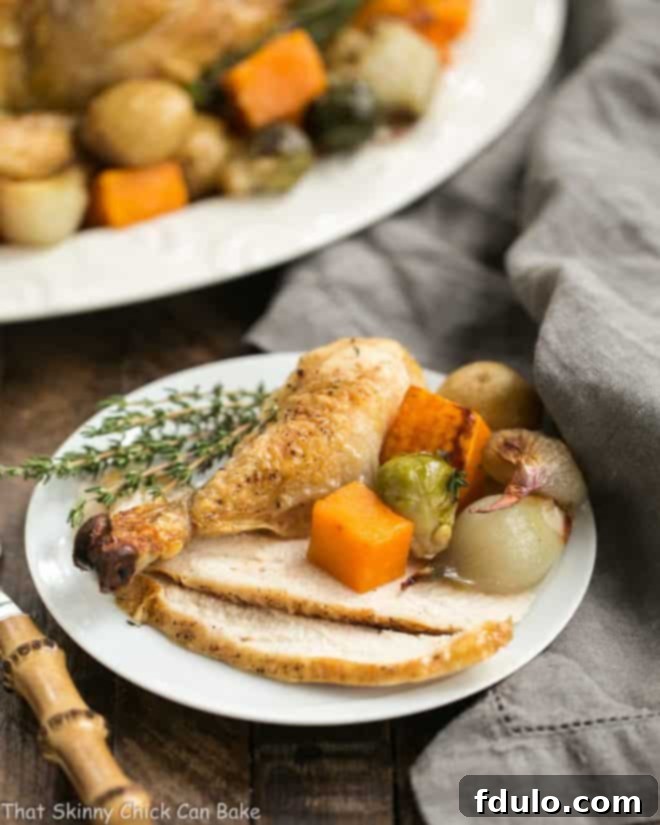 Sheet Pan Chicken with Roasted Fall Vegetables on a platter with a serving on a white plate in the foreground