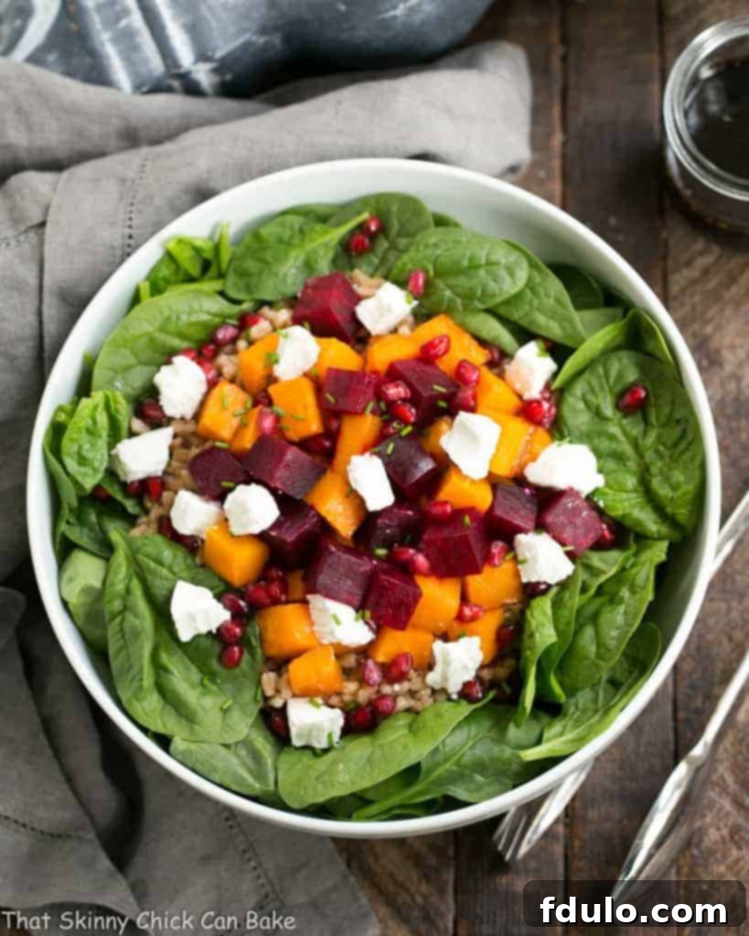 A beautifully composed Roasted Fall Vegetable Salad, highlighting the layers of vibrant ingredients and the inviting texture of goat cheese, ready to be dressed and served.