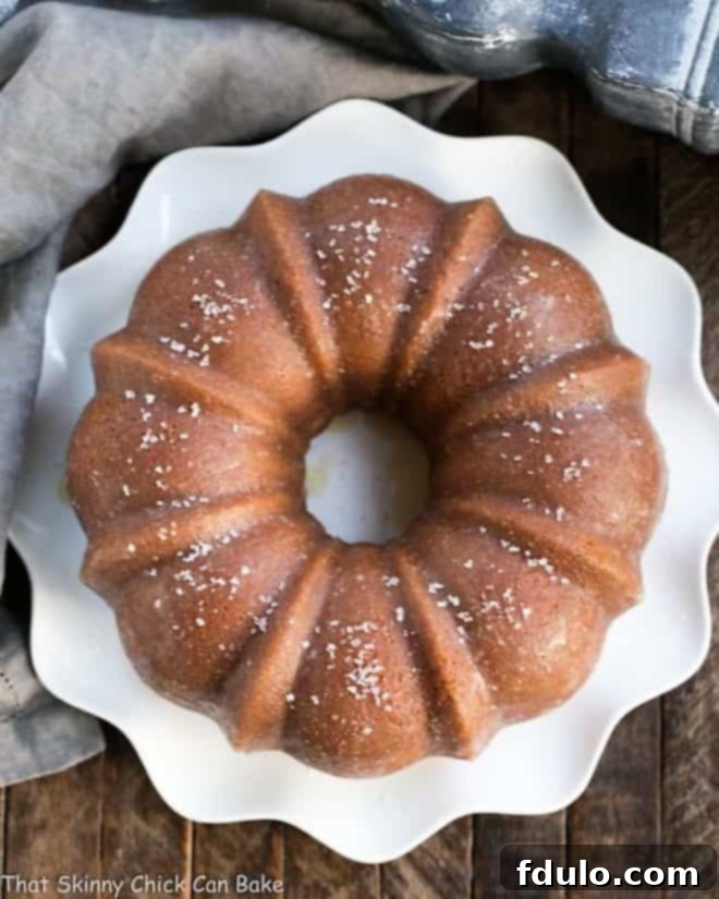 Kentucky Butter Bundt Cake | A simple, versatile butter cake that can be served in so many ways! A beautifully golden Kentucky butter cake baked in a fluted bundt pan, resting on a rustic wooden surface.