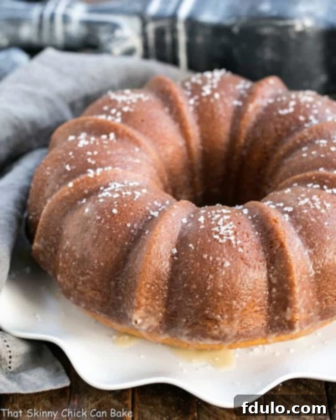 Kentucky Butter Bundt Cake - A simple, versatile butter cake that can be served in so many ways! A whole Kentucky Butter Bundt Cake presented on a beautiful wavy-edged white cake plate, ready to be served.