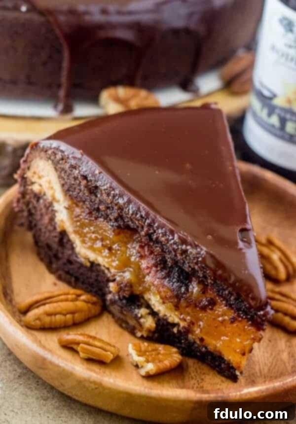 A perfectly cut slice of Chocolate Pecan Piecaken, beautifully revealing distinct layers of rich chocolate cake and a gooey pecan pie filling, creating a stunning cross-section.