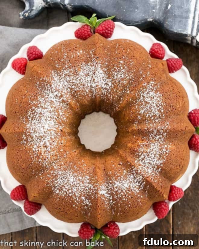 Overhead view of a beautiful white chocolate pound cake presented on a pristine white cake stand.