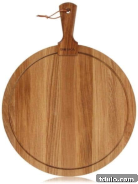 Round wooden cheese board by BOSCA, elegantly showcasing cheeses and crackers