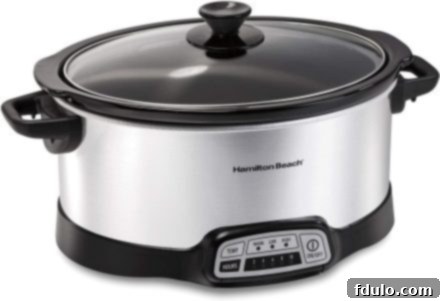 Shiny silver slow cooker with black handles and control panel