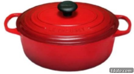 Vibrant red Le Creuset Dutch oven with lid on a clean surface