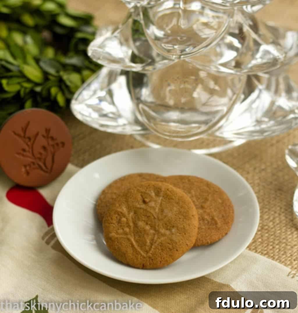 Three perfectly baked crispy ginger cookies arranged on a small white plate, showcasing their golden-brown hue and delicious texture.