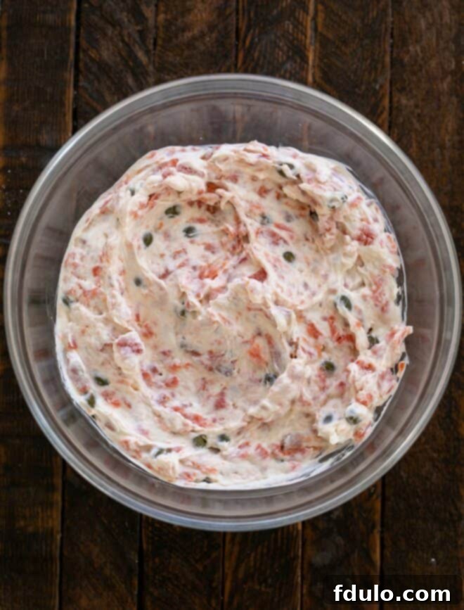 Smoked Salmon dip ingredients being mixed together in a bowl.