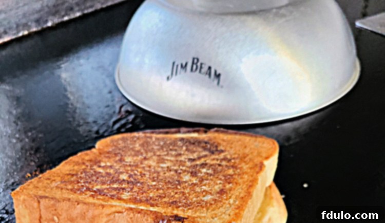Sloppy Joe Grilled Cheese On A Blackstone Griddle next to a Jim Beam melting down 