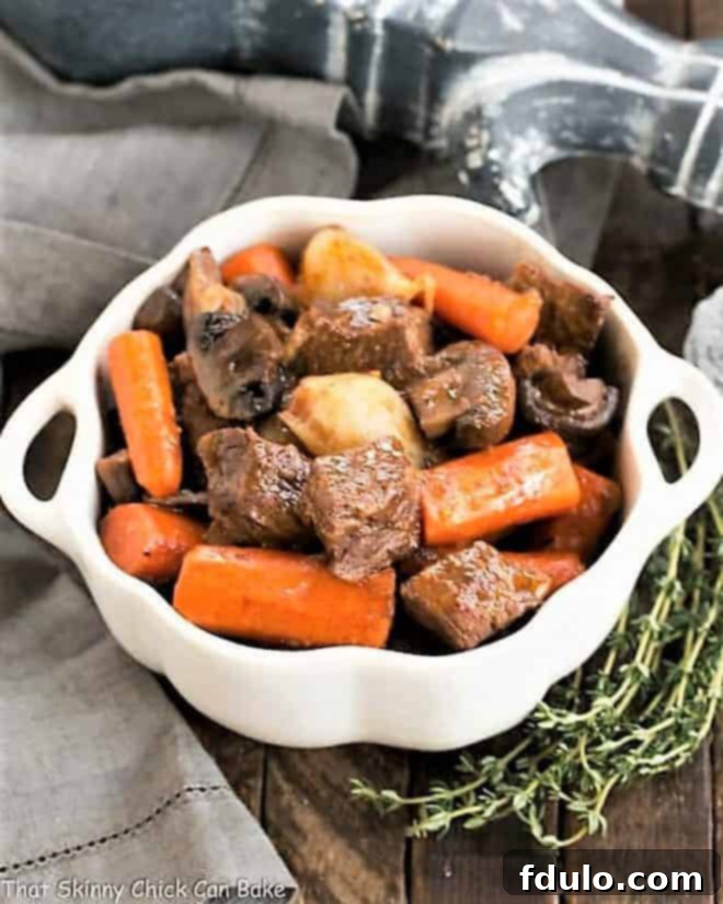 Slow cooker beef stew - a comforting, family friendly crockpot beef stew! Slow cooker beef stew with mushrooms in a casserole dish.