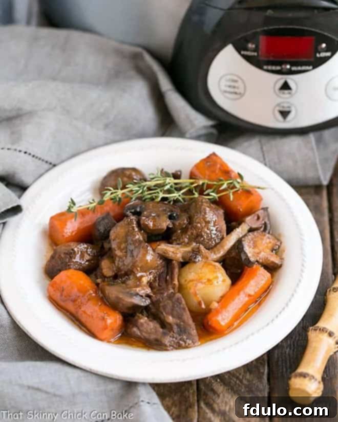 Slow Cooker Beef Stew with Mushrooms - Marvelous comfort food where the crock pot does most of the work! Slow cooker beef stew with mushrooms in a white soup bowl.