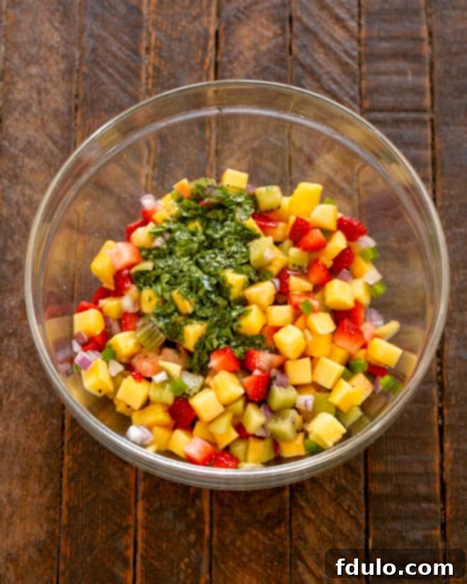 All tropical fruit salsa ingredients combined and mixed thoroughly in a large bowl.