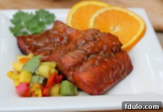 Overhead view of a perfectly plated Glazed Salmon with Fruit Salsa on a pristine white dish, meticulously garnished and ready to serve.
