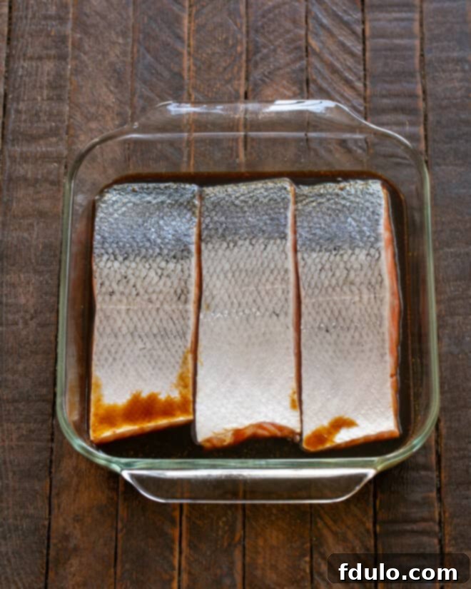 Salmon fillets soaking in the marinade inside a zip-top bag.