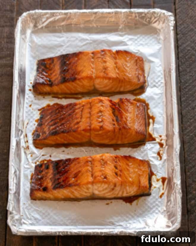 Salmon fillets broiled to a golden-brown finish on a sheetpan.