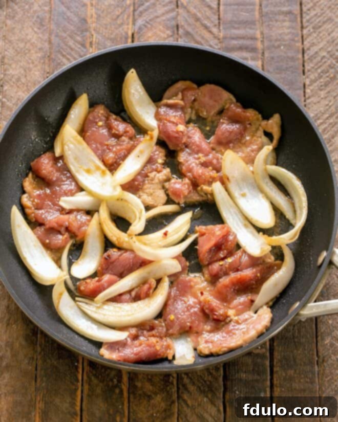 Classic Korean Pork Bulgogi 4 Marinated pork and sliced onions sizzling in a hot skillet, creating enticing aromas and a beautiful sear.