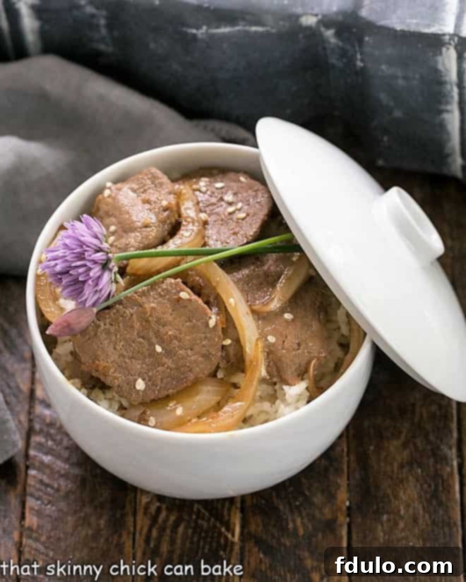 Classic Korean Pork Bulgogi 7 Pork Bulgogi in a white bowl over rice and garnished with chives.